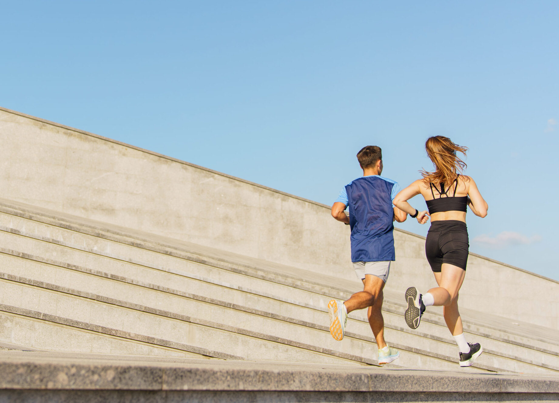 Runners Embrace the Sunlit Day as They Sprint up Modern Steps in an Urban Landscape During Morning Exercise Runners Embrace the Sunlit Day as They Sprint up Modern Steps in an Urban Landscape During Morning Exercise
